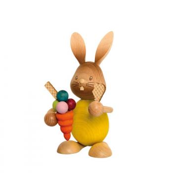 Wooden rabbit Stupsi with yellow shirt holds an ice cream cone in his hand.